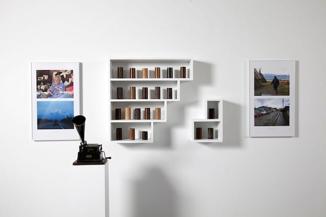 Pablo Helguera, "Conservatory of Dead Languages: Cristina Calderón (b.1929) and Marie Smith Jones (1918–2008)" (2004–present). Wax cylinders, display case, two color photographs, Edison Gem phonograph, and transcripts of interviews with Cristina Calderón and Marie Smith Jones. Dimensions variable.