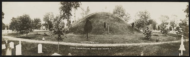Mound in Mound Cemetery showing moat, Marietta, O. Creator(s): Fischer, Harry P., photographer Date Created/Published: c1908. Medium: 1 photographic print (postcard) Summary: Postcard shows earth mound in cemetery.