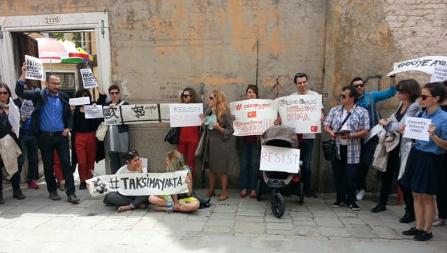Protesters at a solidarity rally in Venice during the Venice Biennale included Arsenale protest with pavilion artist Ali kazma pavilion curator emre baykal salt curator duygu demir Istanbul biennial curator fulya erdemci witte de with director Defne Ayas. The artwork poster was provided by Qiu Zhijie. (images courtesy Defne Ayas)