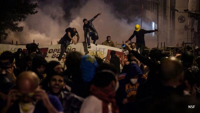 Protesters jump over one of the many barricades that currently protect Taksim Square from the Police’s crowd-dispersion tanks. (photo: Nazim Serhat Firat, and used with permission)