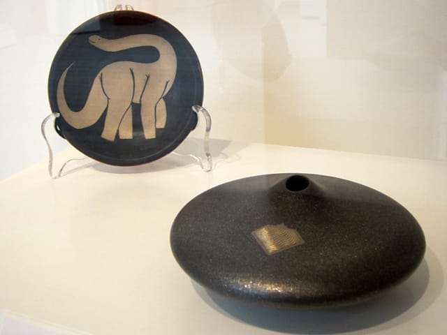 William Andrew Pacheco, "Black-and-white Plate (brontosaurus)" (1980s), native clays; Preston Duwyenie, "Black Seed Pot with Silver Inlay" (n.d.), micaceous clay, silver