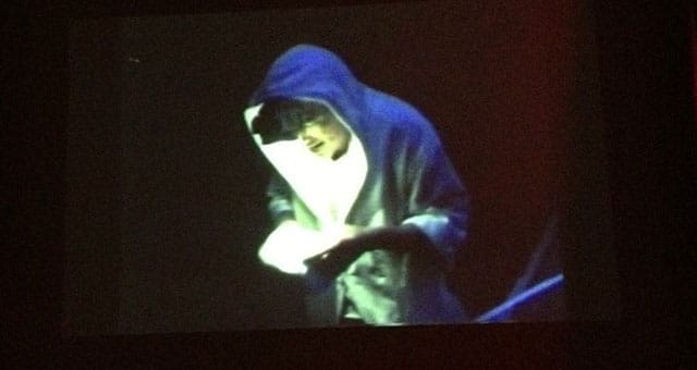 Photo of film screening John Fleck performing in his work , 1992. (Source: New Museum