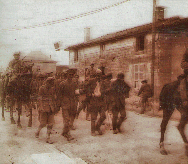 Prisoners being walked down the street by armed guards