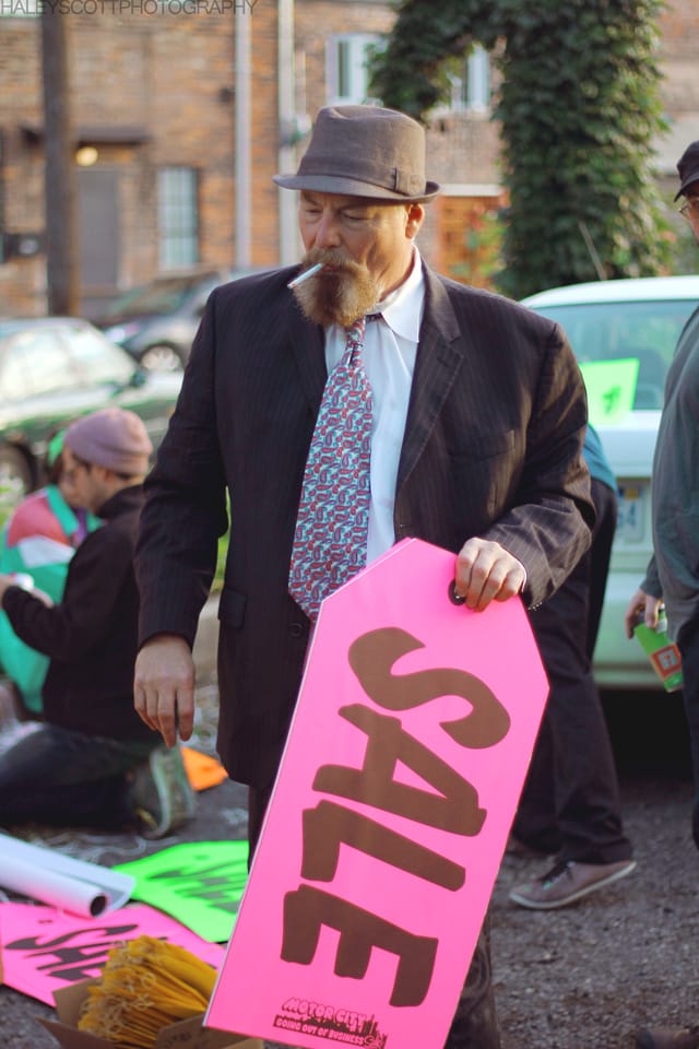 Jerry Vile with one of the tag sale signs for his project "The Selling of Detroit"