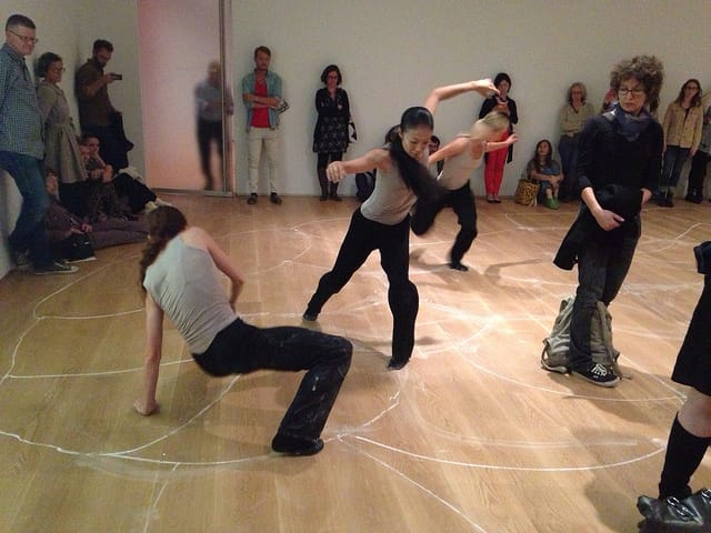 Dancers erasing the chalk lines as they dance.