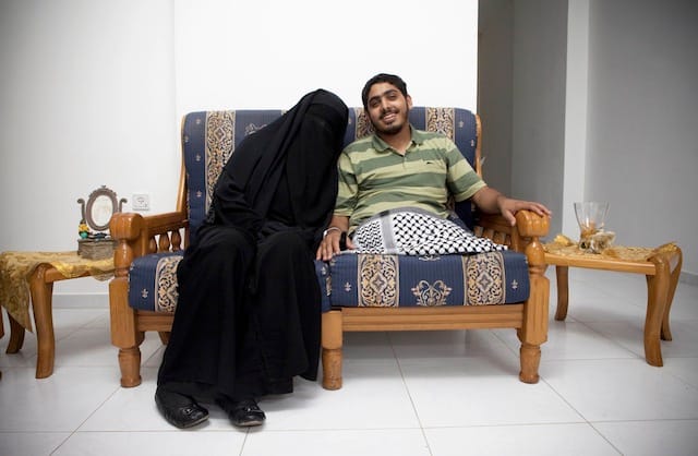 Tanya Habjouqa, from the series "Women of Gaza." Text for the photograph: "Moemen Faiz, a photographer, sits with his new wife, Deema Ayideh, at the couple's home in Gaza. Faiz was injured during Israel's assault on Gaza in the winter of 2008-09, and was later flown to Saudi Arabia where he received treatment. The two fell in love when Ayideh, a journalist, interviewed Faiz at the hospital, and they married soon after."