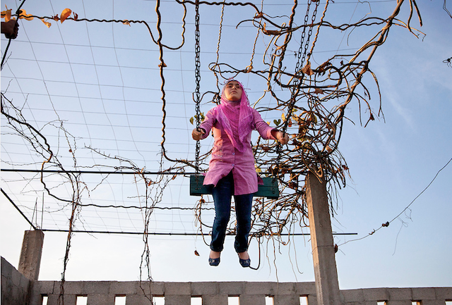 Tanya Habjouqa, from the series "Women of Gaza." Caption: "Young girl relaxes at her family farm "vacation" spot on the outskirts of Gaza city. Travel is next to impossible for the majority of Gazans due to the siege, but the Palestinians remain creative and hopeful. BBQs with the family remains a top day off from school for these young girls."