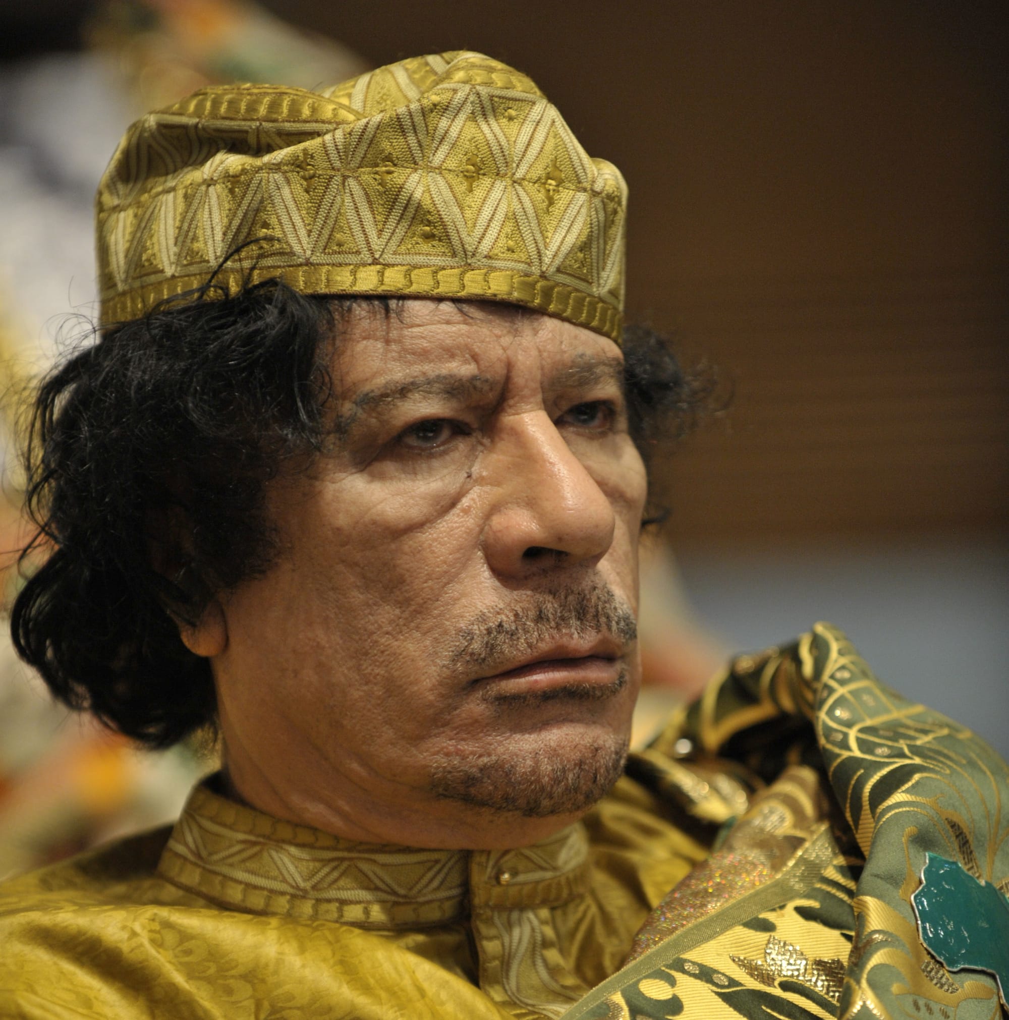 Muammar Gaddafi, Leader of the Revolution of the Great Socialist People’s Libyan Arab Jamahiriya, sits reading in the Plenary Hall of the United Nations (UN) building in Addis Ababa, Ethiopia, during the 12th African Union (AU) Summit