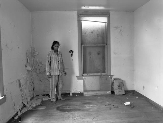 LaToya Ruby Frazier, "Self Portrait In Gramps’ Pajamas, (227 Holland Avenue)", 2009, 20 x 24 inches. Silver Gelatin Print. Courtesy of the artist and Galerie Michel Rein, Paris.