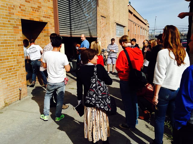 The audience watches the new Greenpoint Banksy getting covered up. (photo by the author for Hyperallergic)