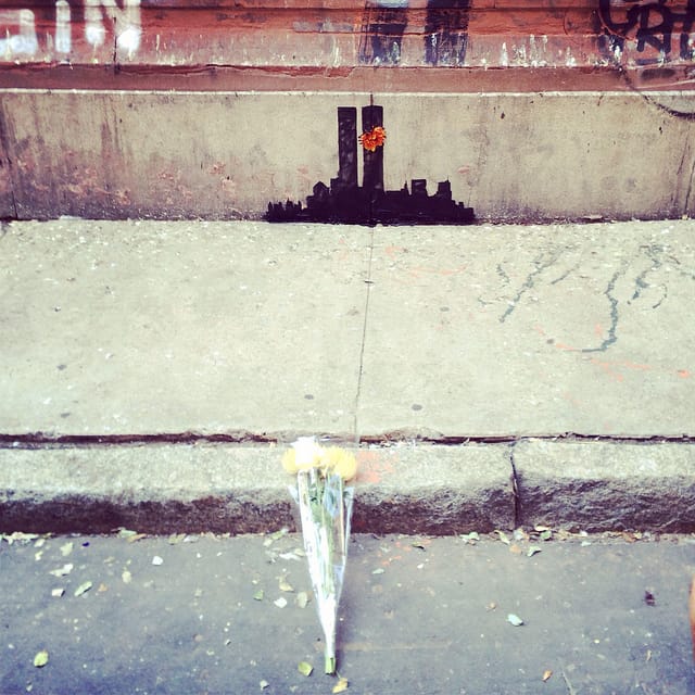 Someone had placed flowers by the Tribeca Banksy. (all photos by the author for Hyperallergic)