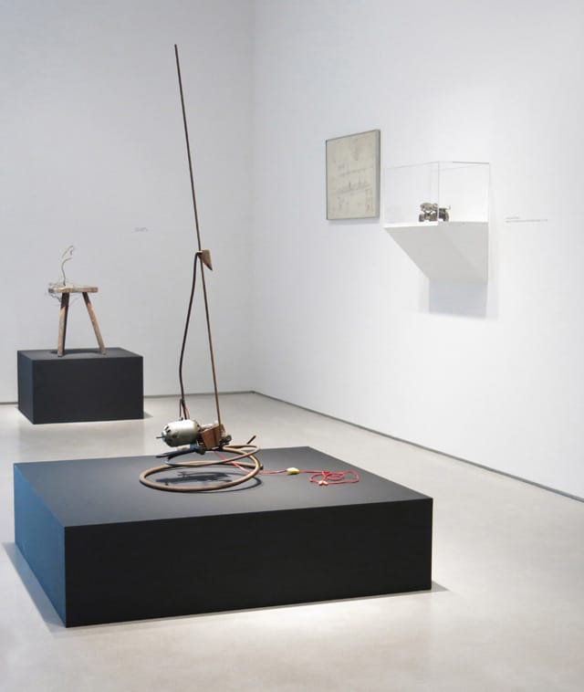 "Radio Waves" installation view: from left, Jean Tinguely, "Saint Phalle" (1961), wooden stool, metal, and pigments, 28 ½ x 14 x 16 ½ inches; Jean Tinguely, "Untitled" (1962), metal, plastic, and electrical wire assemblage with  electric motor, 57 ½ x 20 x 18 ½ inches; Per Olof Ultvedt, "Drawing for Project" (1962), pencil on paper, 19 x 28 inches; Niki de Saint Phalle, "Element of Tir tableau pour DYLABY (Roller Skate)" (ca. 1962), painted metal and leather, 4 ¼ x 11 ¼ x 3 3/8 inches.