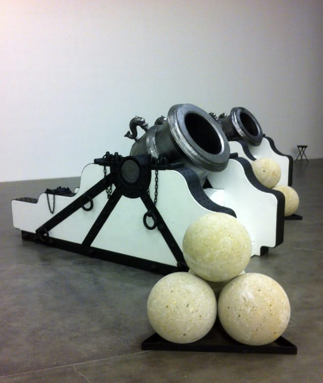 Chris Burden, "Pair of Namur Mortars" (2013). Bronze, wood, iron, steel, stone. Dimensions: Each mortar: 60 × 132 × 48 inches. Each stack four cannon balls: 36 × 36 inches. Approximate weight of each mortar, cradle, and four cannonballs: 12,000 lbs. Courtesy the artist and Gagosian Gallery.
