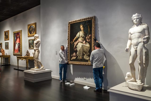 Art handlers installing Bernando Strozzi's "St. Catherine" in the galleries of the Los Angelese County Museum of Art. (image courtesy © 2013 Museum Associates/LACMA)