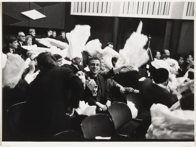 Benjamin Patterson, audience members participating in "Paper Piece" (1960), performed during Fluxus Festival/Theatre Compositions/Street Compositions/Exhibits/Electronic Music, Hypokriterion Theater, Amsterdam, June 23, 1963; gelatin silver print, 6 15/16 x 9 1/2″ (17.7 x 24.1 cm)(photographer: Oscar van Alphen) (The Museum of Modern Art, New York, The Gilbert and Lila Silverman Fluxus Collection Gift) (photo: Peter Butler)