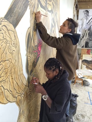 Some of Swoon's studio assistants working on a large piece.
