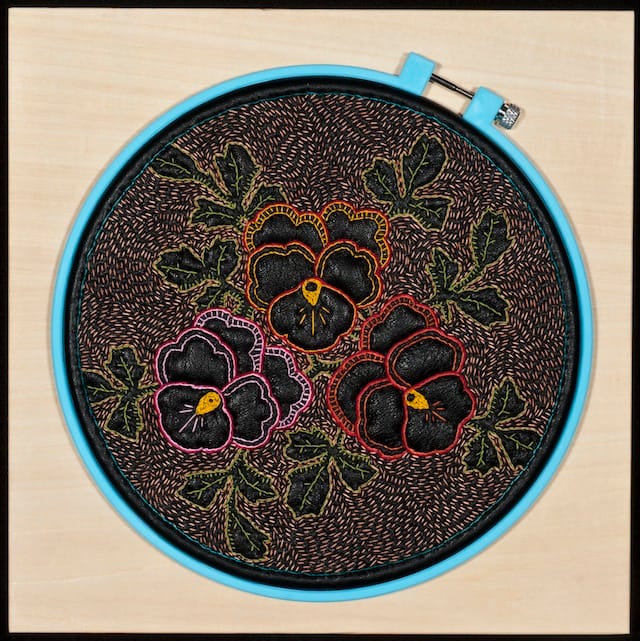 John Thomas Paradiso, "Leather Pansy II," (2010). Leather, thread, and plastic hoop on wood panel 10 x 10 x 1.5 in. Courtesy of Elisabeth Jacobsen. Photo credit: John Thomas Paradiso.