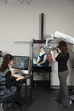 Conservators and scientists use a high-power microscope and X-rays to examine the pigment particles and individual brushstrokes of Renoir’s Madame Léon Clapisson, 1883