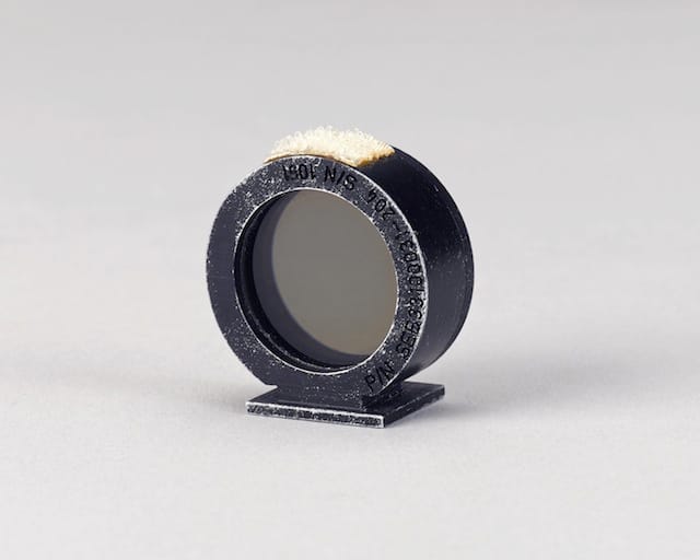 MOTION PICTURE RING SIGHT USED ON THE MOON DURING APOLLO 15.  Flown Maurer DAC (Data Acquisition Camera) sighting ring. Circular metal ring, 1¼ inches in diameter with an optical component at the center.   Est. $20,000-30,000 
