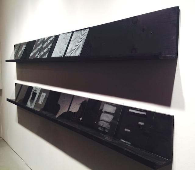 Visitors were invited to select one of these glass templates and place it over the "post-private" object of their choosing. Photo by the author for Hyperallergic. 