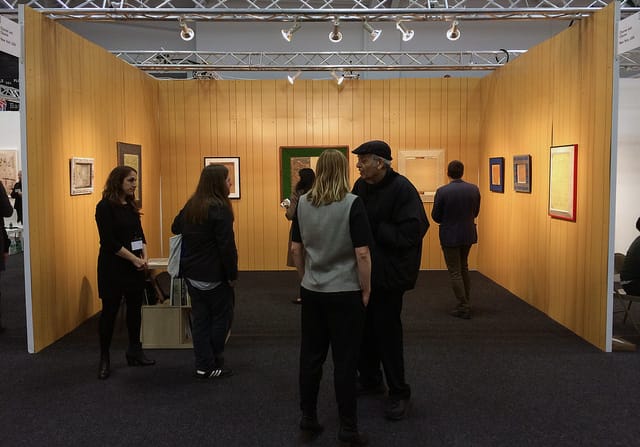 Churner and Churner's wood paneled booth with 1980s tape works by Jaime Davidovich.
