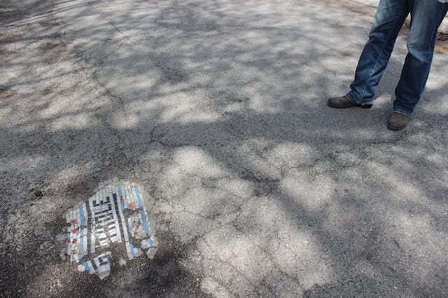 Bachor stands with his first pothole mosaic outside his home in Chicago's Mayfair neighborhood.