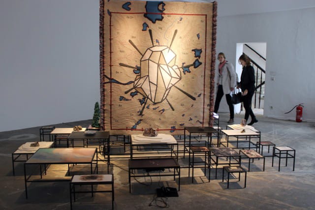 Otobong Nkanga, “In Pursuit of Bling, 2014), videos/Inkjet prints, lightbox, metal modulated structure, minerals, objects, texts, videos with sound, woven textile pieces, Dimensions variable, Installation view