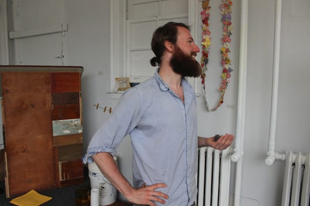 Joshua Kent holds the pod that he's growing during his seven-day residency at Roman Susan gallery (all photos by the author for Hyperallergic)