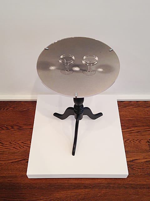 Robert Watts, "Table with Two Wine Glasses" (1965), black and white photograph, Plexiglas disc, mounted on table, unique, 14" diameter 