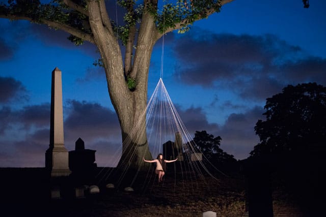 A performer in “Crossing Over: A Performance Adventure in Green-Wood Cemetery” (all photos by Monica Simoes, lighting design: Mike Faba)
