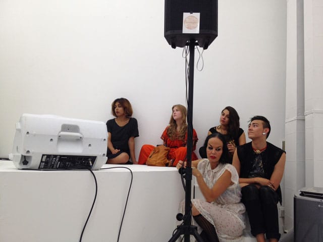 Artist Kembra Pfahler (in white dress) sits on stairs with audience members during the 'Future Feminism' performance/lecture given by Sarah Schulman on September 12. (click to enlarge)