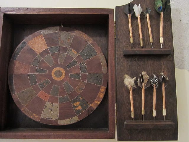 Jackie Mock, "Center,"a dartboard with inlaid soil from all 50 states, with the geographical center of the US as the bullseye, and darts with feathers of North American birds