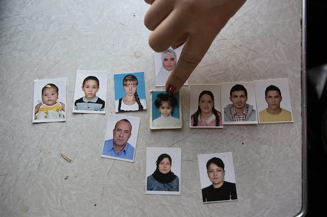 A young woman points out a picture of her daughter, who she left with relatives so she could work in Moscow. 