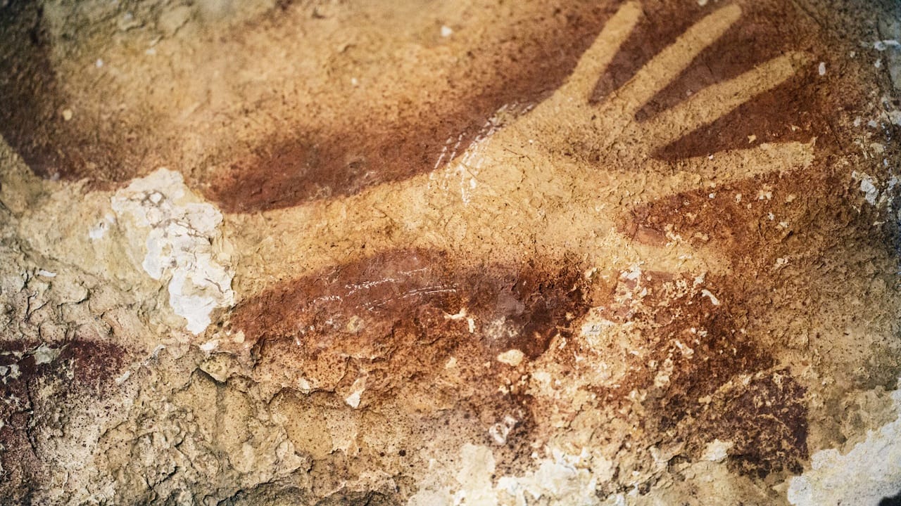 Hand stencil in a cave in Indonesia, dated to at least 39,900 years old (photograph by Kinza Riza, via Nature.com)