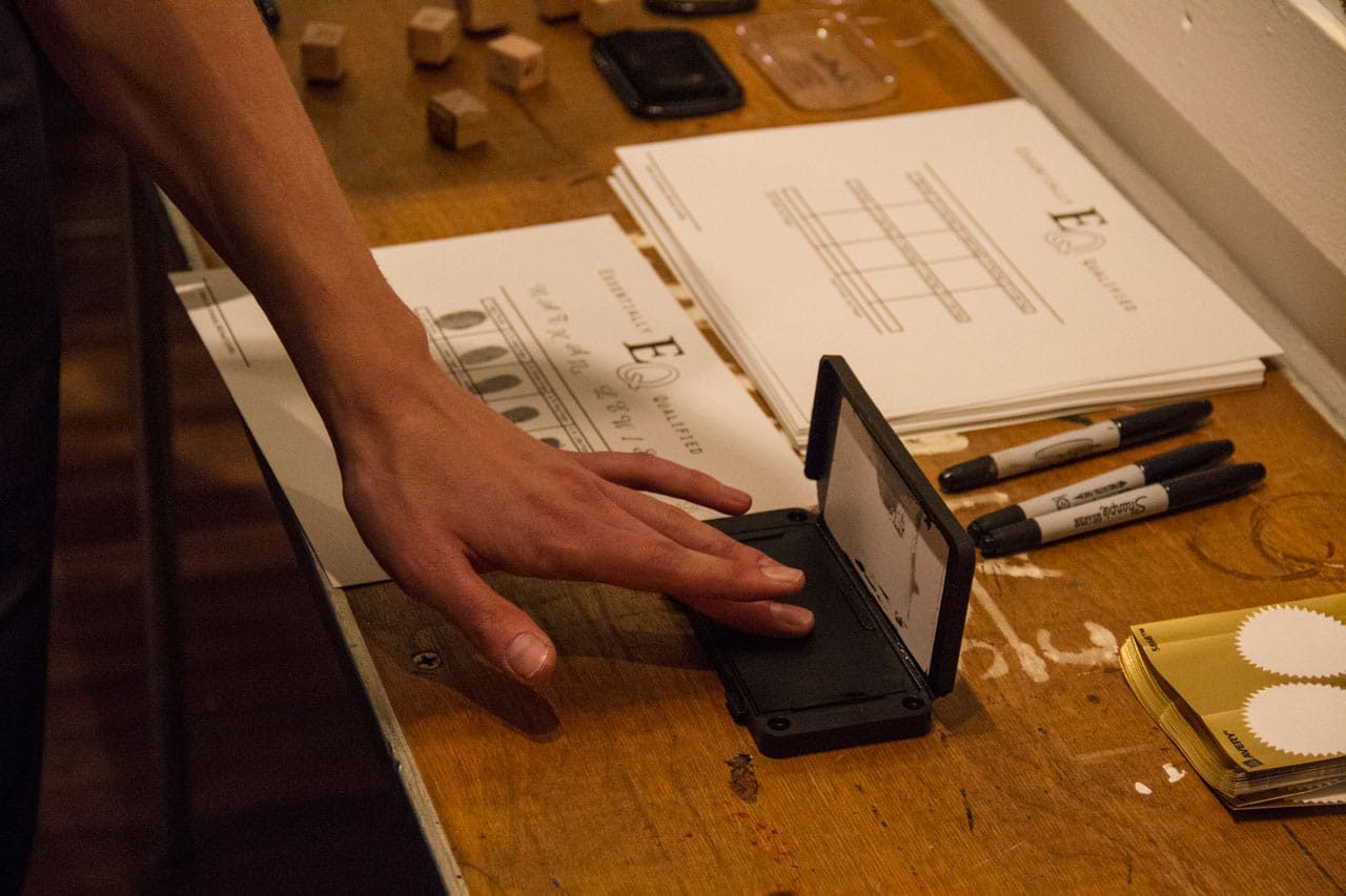 Participant creating a hands-on diploma at Paul Shortt's "Diploma Station" (2014), stamps, seals, and certificates