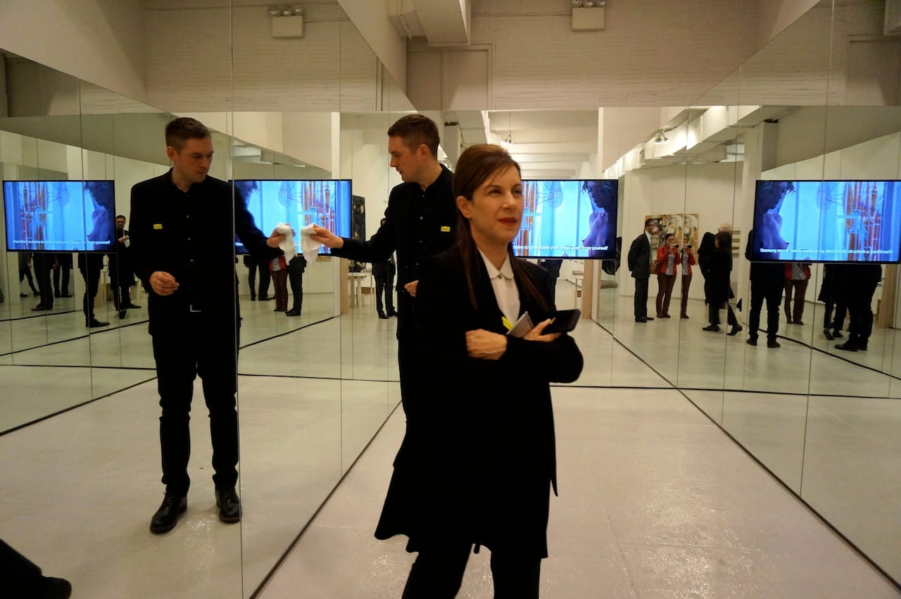 Cleaning Liam Gillick's mirrored room, which houses his film "Hamilton: A Film by Liam Gillick" (2014), at Marueen Paley