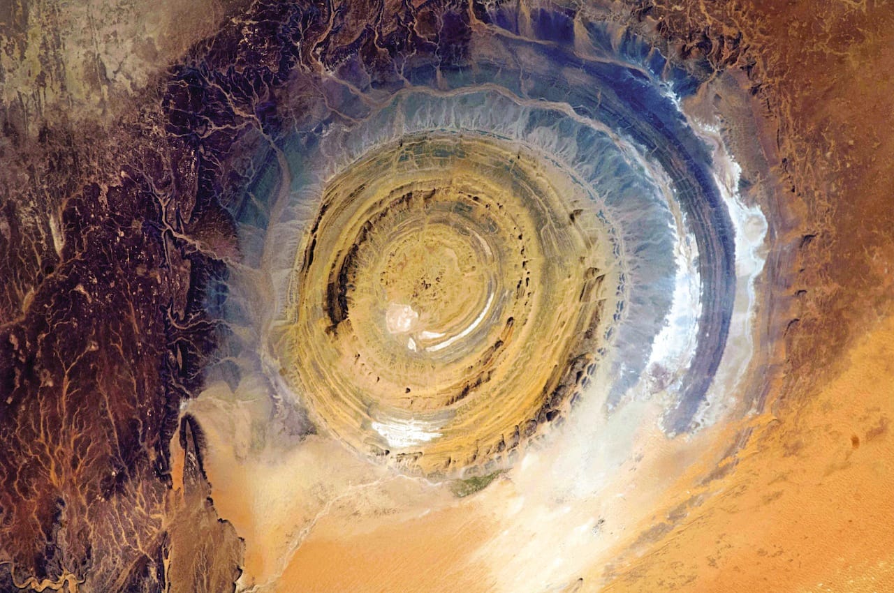 Mauritania The Richat Structure in Mauritania, also known as the Eye of the Sahara, is a landmark for astronauts. If you’ve been busy doing experiments and haven’t looked out the window for a while, it’s hard to know where you are, especially if you’re over a vast 3,600,000-square-mile desert. This bull’s-eye orients you, instantly. Oddly, it appears not to be the scar of a meteorite but a deeply eroded dome, with a rainbow-inspired color scheme.