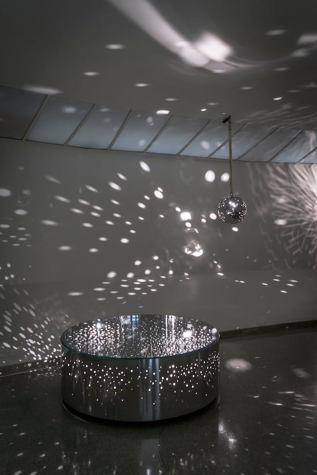 Otto Piene, Light Ballet (Lichtballett), 1961–69. Left to right: Light Ballet (Light Drum), 1969, chrome, glass, and lightbulbs, height: 45.7 cm, diameter: 124.5 cm, Moeller Fine Art, New York; Light Ballet (Light Satellite), 1969, chrome and lightbulbs, diameter: 38 cm, Moeller Fine Art, New York; Light Ballet, 1961, metal armature, lightbulbs, electric motor, and rubber, 178 x 155 x 80 cm, Foundation MUSEION. Museum of Modern and Contemporary Art Bolzano, Italy © Otto Piene. Photo: David Heald © The Solomon R. Guggenheim Foundation, New York