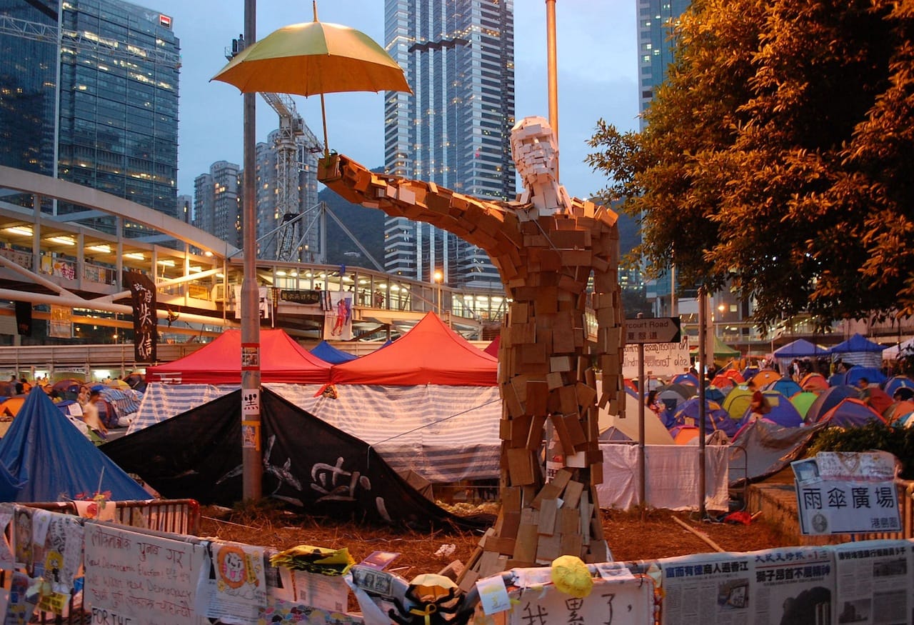 Umbrealla Man statue in Hong Kong (Image via Wikimedia) 