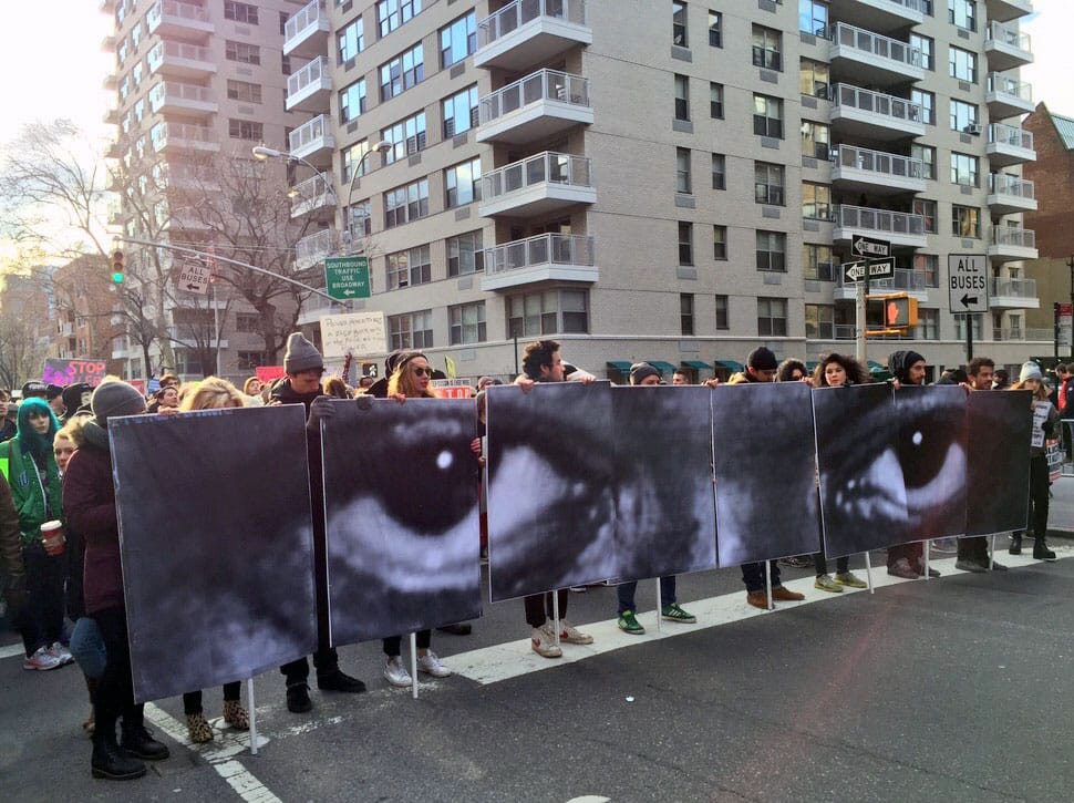 Artist JR created these works that depict the eyes of Eric Garner, the man choked to death by NYPD officers, which appeared in yesterday's Millions March in Manhattan. (photo by the author for Hyperallergic)