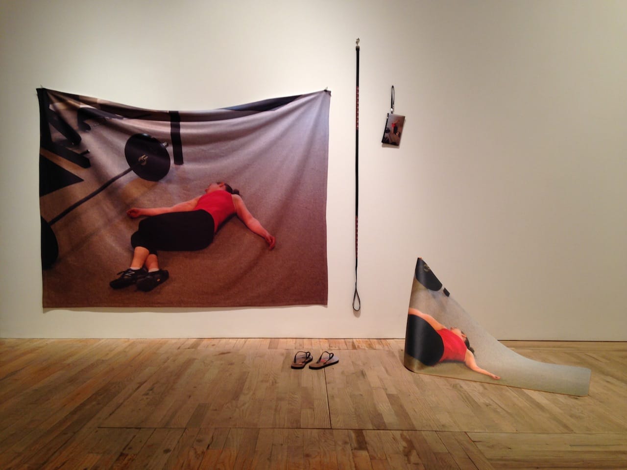 Eva and Franco Mattes, "Agreement #1 (Internet image search result for 'exhausted' printed on various objects by online services)" (2014), print on blanket, wristlet, dog leash, yoga mat, flip-flop, contract, dims as installed (photo by Jillian Steinhauer for Hyperallergic) (click to enlarge)