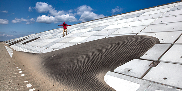 Paula Bronstein, A woman makes her way down the seawall along the Kitakama and Ainokama coastline in Sendai, Japan (via annenbergfoundation.org)