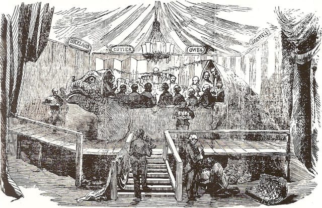 The famous banquet in the mould of the Crystal Palace Iguanodon, New Year's Eve, 1853. As depicted in the Illustrated London News and scanned from The Illustrated Encyclopaedia of Dinosaurs (via Wikipedia)