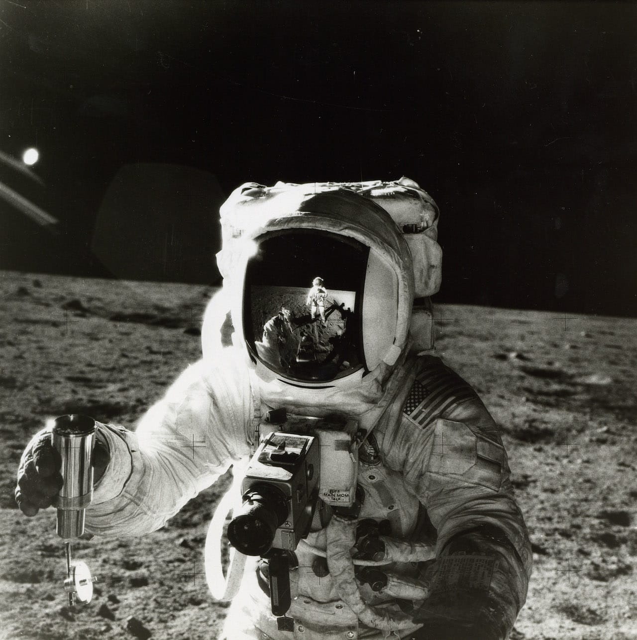 Pete Conrad Alan Bean with the reaction of the photographer in his visor, EVA 2, Apollo 12, November 1969 Vintage gelatin silver print, 20.3 x 25.4cm (8 x 10in), NASA MSC caption on verso, numbered NASA AS12-49-7278 in black in top margin Alan Bean holds a container of lunar soil in his right hand. His Hasselblad camera is mounted on the control unit on his chest. Illustrated: Full Moon plate 69, The View from Space p.46