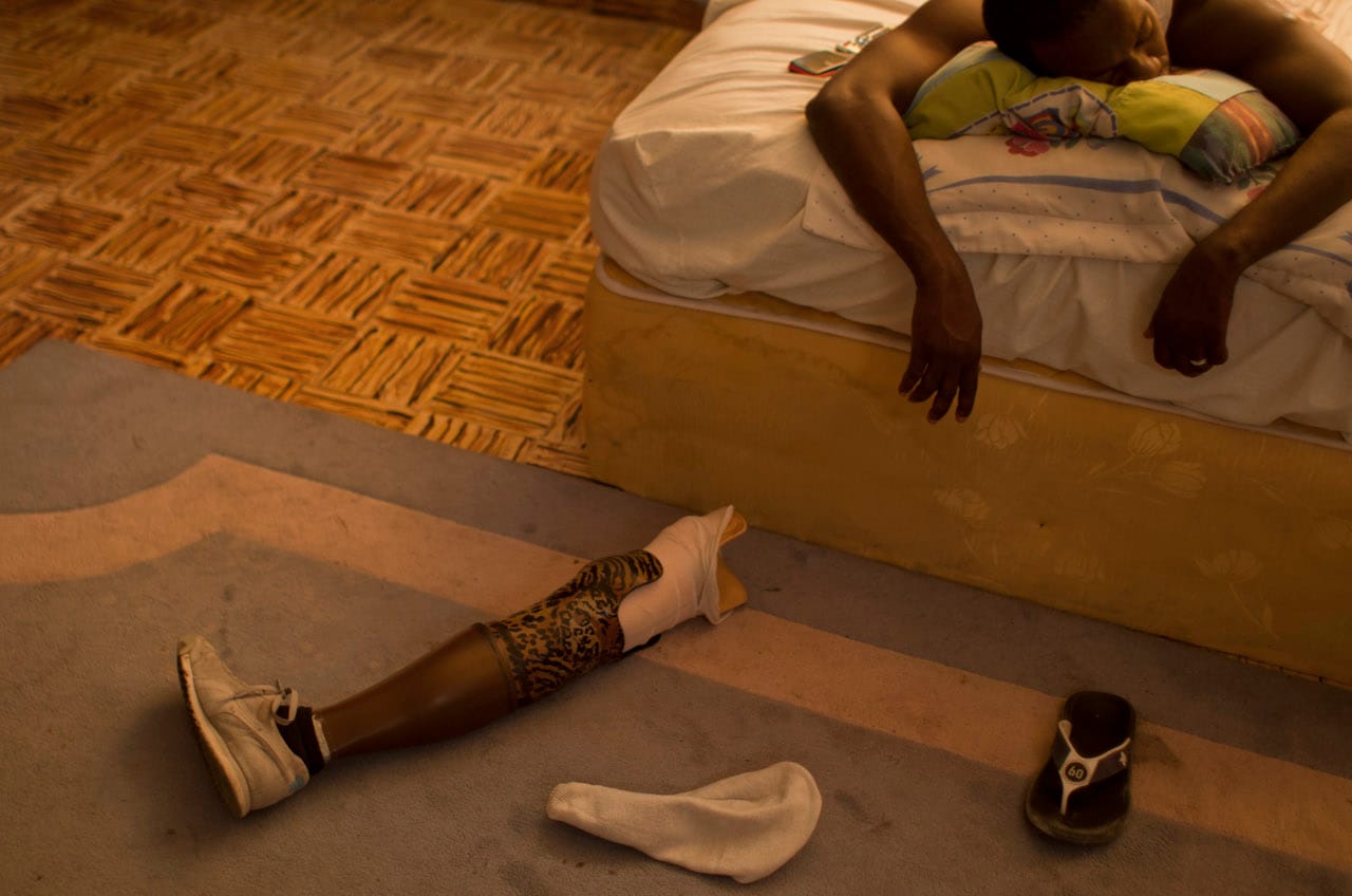 Georges Exantus. In this Jan. 17, 2013 photo, professional dancer Georges Exantus sleeps as his prosthetic limb lays on the floor in his bedroom in Port-au-Prince, Haiti. Exantus thought he’d never dance again. He was lucky just to be alive. The earthquake three years ago in Haiti’s capital flattened the apartment where he was living, where he spent three days trapped under a heap of jagged rubble. After friends dug him out, doctors amputated his right leg just below the knee. Exantus says he has learned to ignore the long stares and quiet whispers, products of a longstanding stigma in Haiti for people with disabilities. Before the quake, few resources existed to accommodate Haiti’s disabled, and many regard people with disabilities as misfits. © Dieu Nalio Chery/ AP Photo.