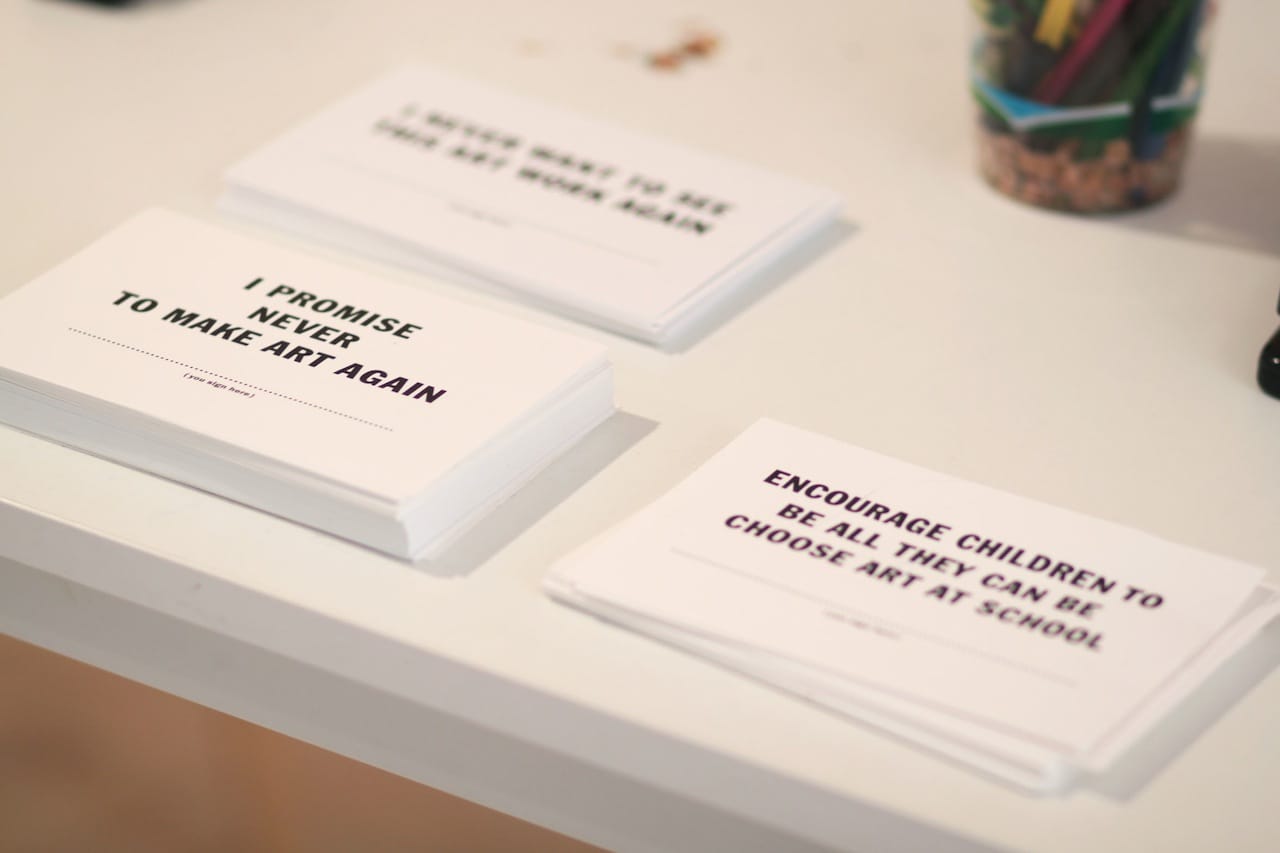 Artist pledge cards at the exhibition's front desk