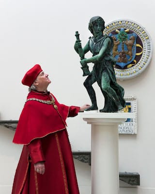 Actor Paul Jesson as Cardinal Wolsey with the reunited four bronze angels (courtesy Victoria and Albert Museum, London)