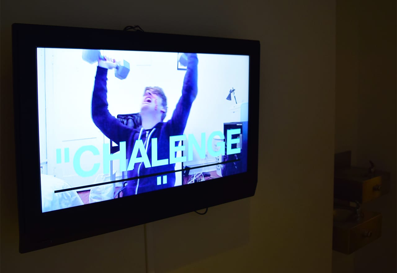 Steve Roggenbuck's "My Satanic Fitness Regimen (2011) VERY DEMONIC, WOW MOST EVIL VIDEO!!! 666!!!" (2011) in the hallway leading to the basement bathrooms