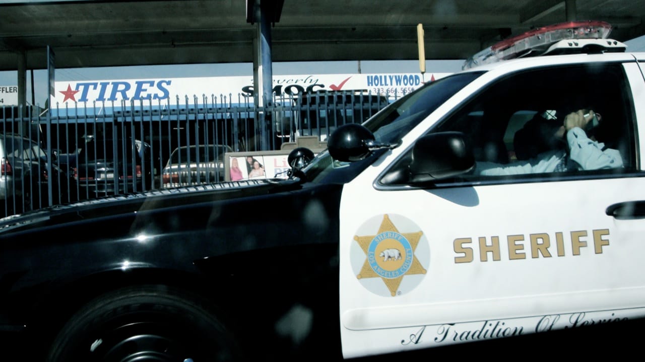 An LA County Sheriff's Department deputy talking on the phone while driving — which is illegal in California. (photo by Heather Anne Campbell/Flickr