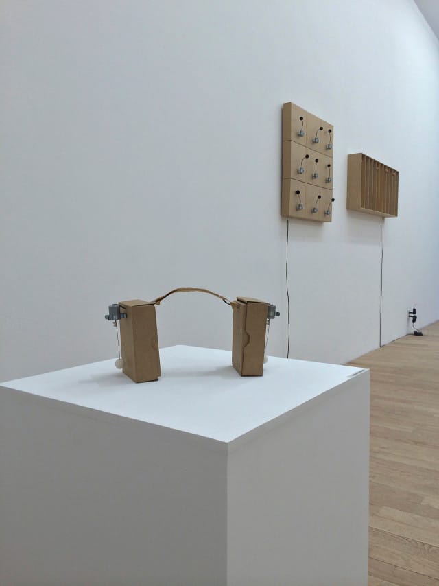 Installation view of Zimoun's "2 prepared dc-motors, cotton balls, cardboard boxes 16.5x12x5cm" (2013)
